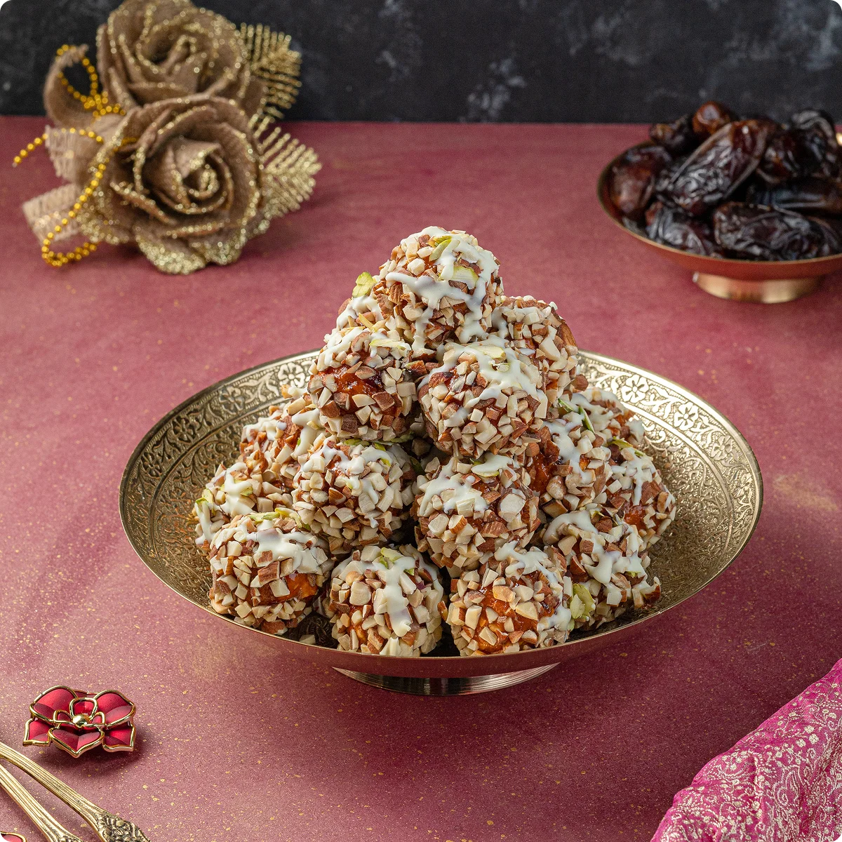 A brass bowl of dry fruit laddoos